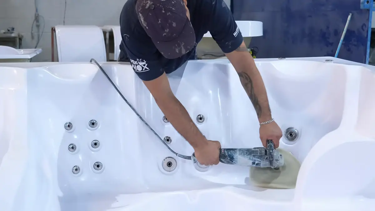 Colaborador da Lineaplas instalando os jatos de hidromassagem em um spa na linha de montagem